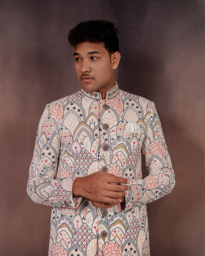 Luxe men’s white velvet Indo-Western outfit with vibrant multi-colored embroidery, designed for grand occasions and special events.