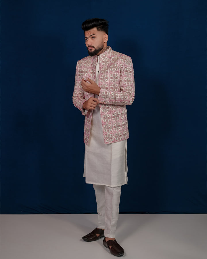 A regal rose pink Jodhpuri set for men featuring intricate embroidery and a sophisticated design.